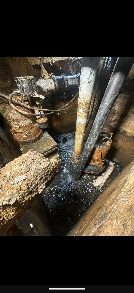 Vue latérale d'un puisard de fondation avec pompes et conduites de drainage avant nettoyage