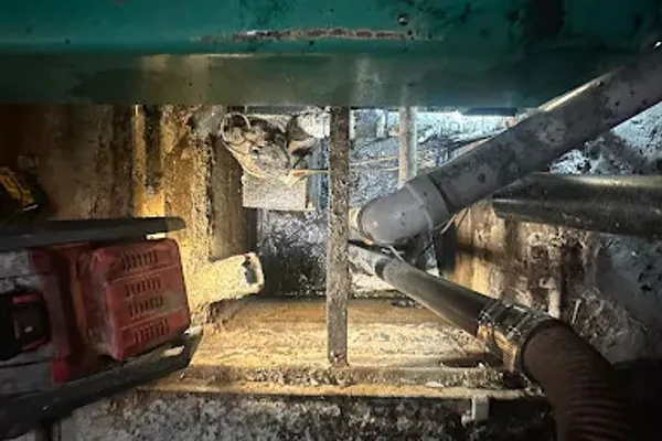 Top view of a commercial sump pump pit before seasonal cleaning